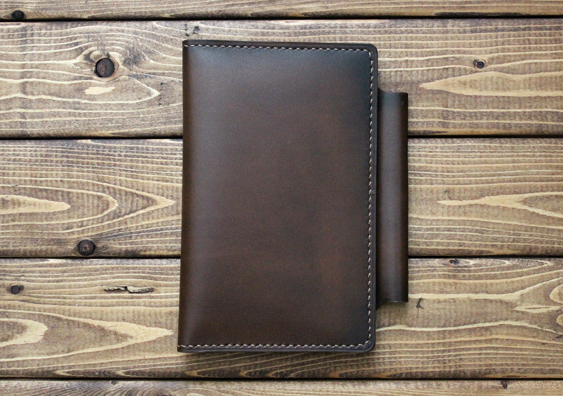 A hand burnished Italian brown leather notebook cover with a pen holder. The cover is crafted with visible hand stitching and has a vintage charm. Personalized journal cover