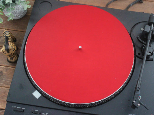 A red full grain leather turntable mat placed on a turntable